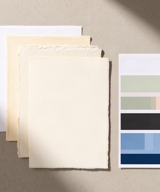 Organized paper stock samples showing white, cream, and textured sheets beside a printed color swatch